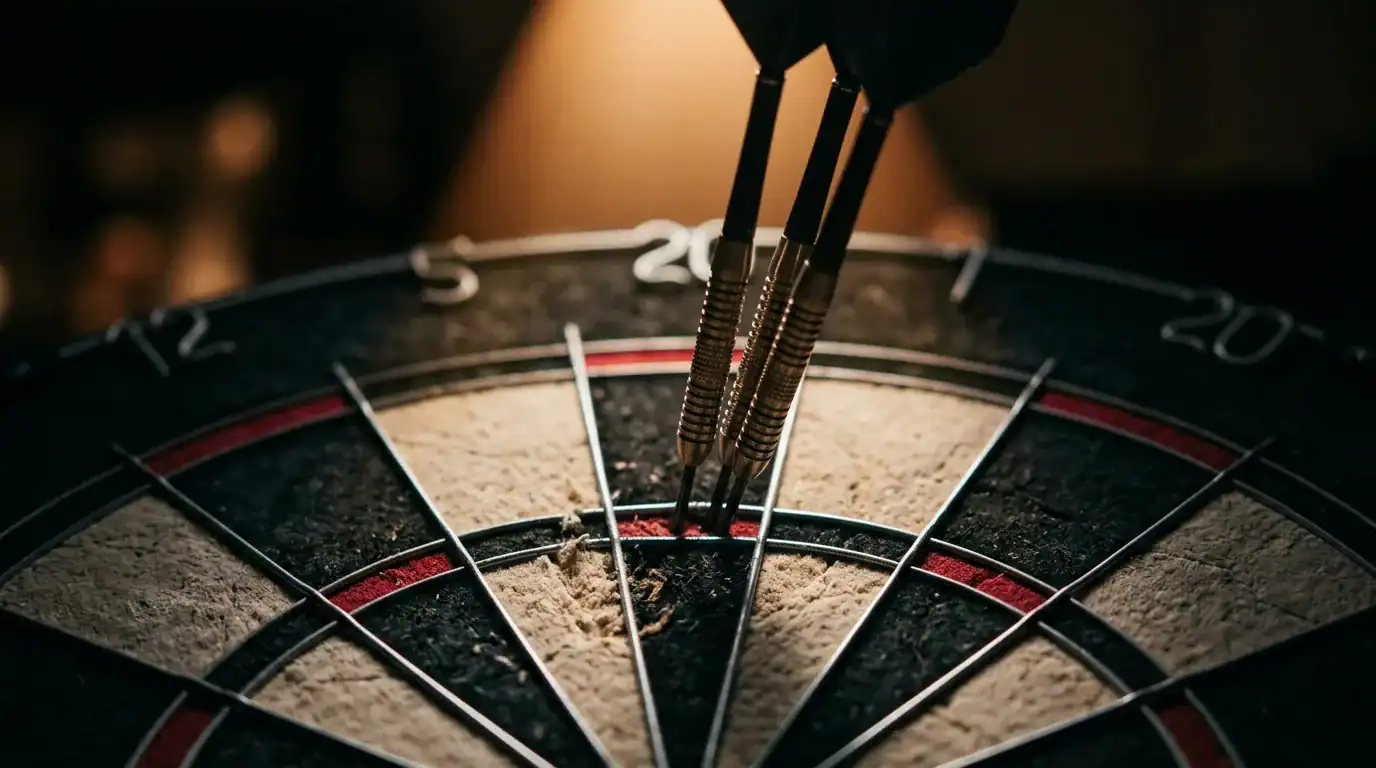 Three steel-tip darts grouped tightly in the treble 20 bed of a bristle dartboard under warm spotlight