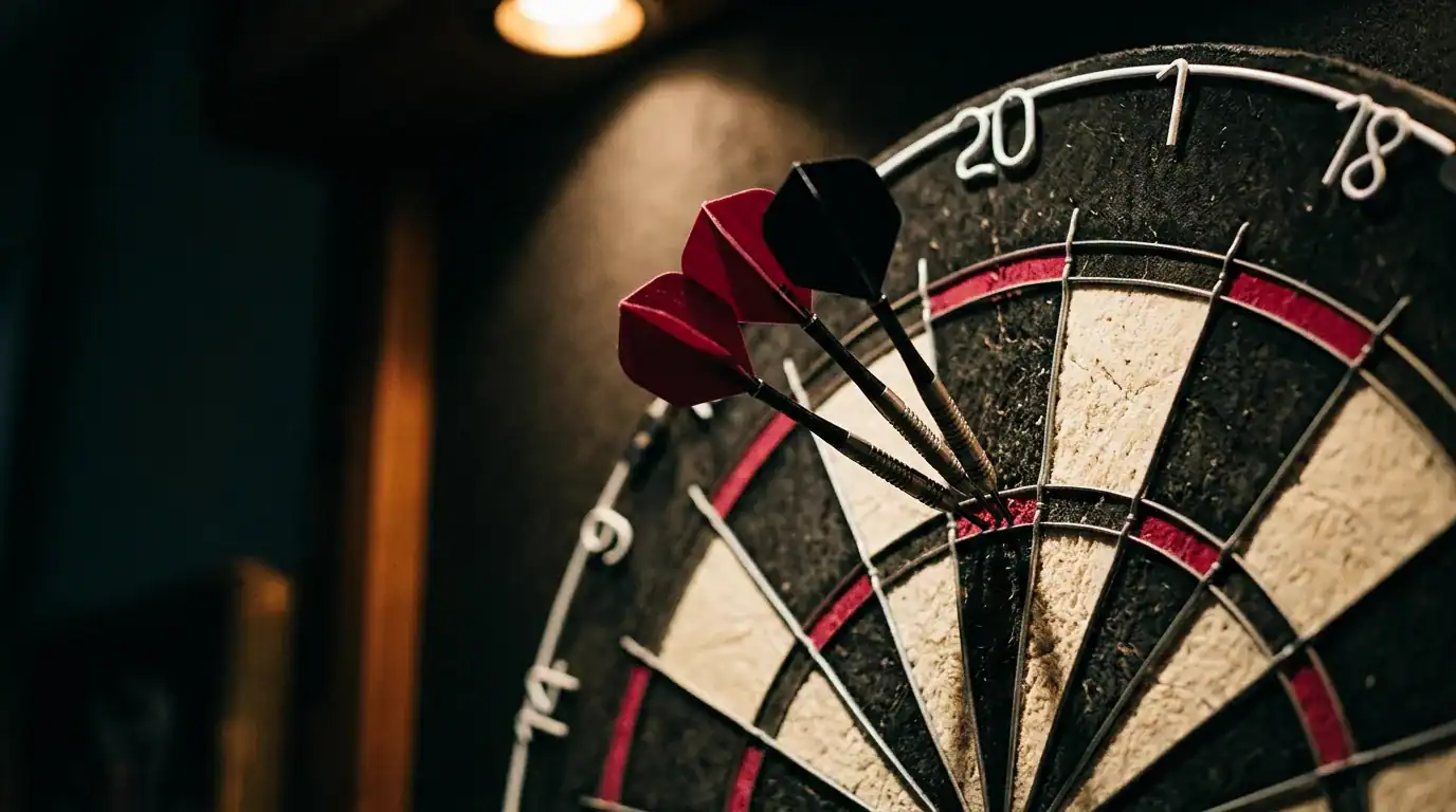 Three darts grouped tight in the treble 20 bed of a bristle dartboard