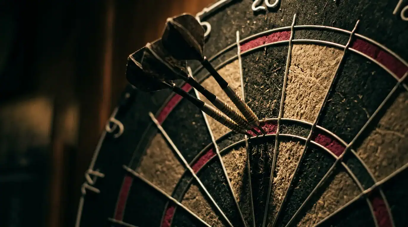 Three steel-tip darts grouped in the treble 20 bed of a bristle dartboard