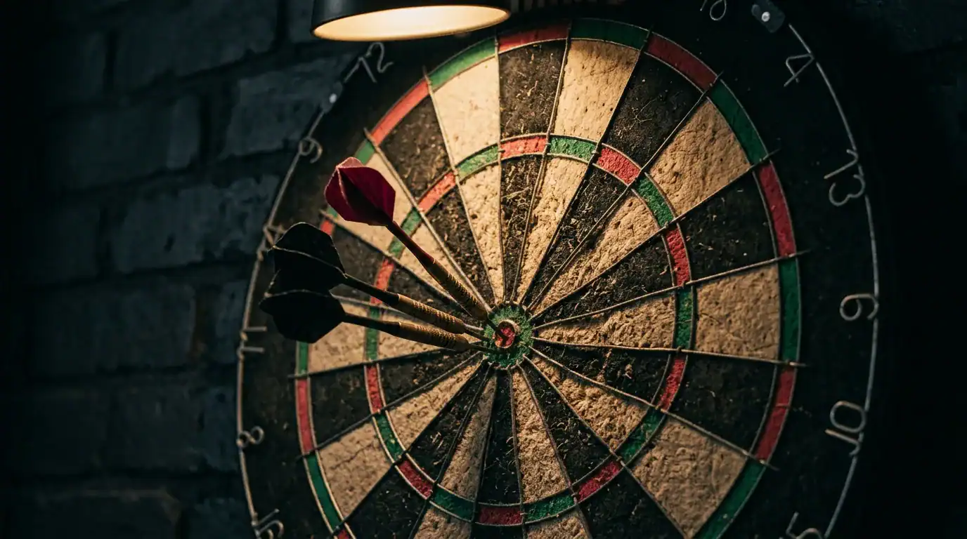 Three darts clustered near the bullseye of a well-used bristle dartboard under warm light