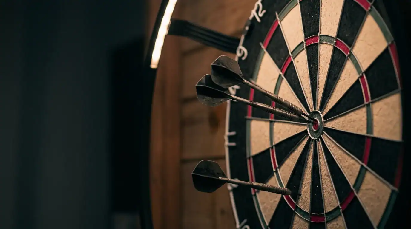 Three darts grouped near the bullseye on a bristle dartboard during a practice session