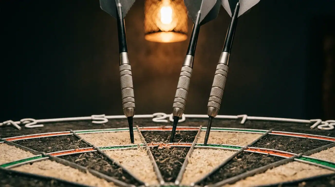 Three darts with different point lengths embedded in a bristle dartboard showing clearance differences