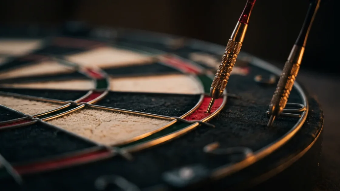 Two darts at the edge of a dartboard under a warm spotlight, one in the double bed and one just outside the wire